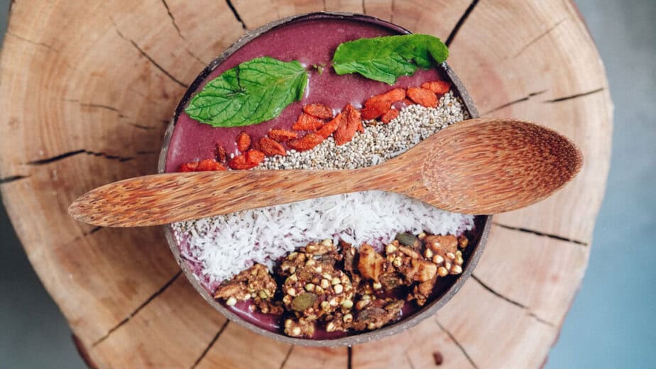 Zdravá smoothie bowl s bobulemi goji, chia semínky, kokosovými vločkami a granolou. Goji a další superpotraviny v misce podporují imunitu a celkové zdraví.